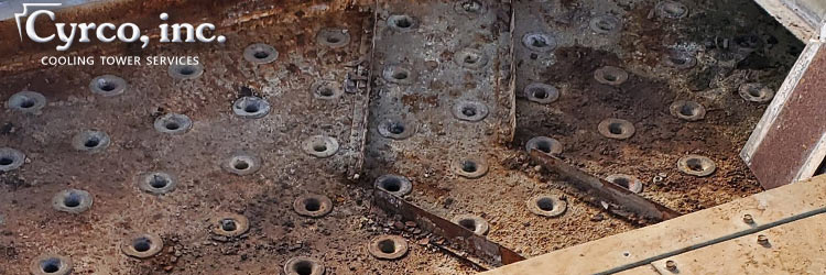 Dirty, Rust Riddled Hot Water Distribution Basin on a Metal Cooling Tower Before Cyrco's Cleaning Service.
