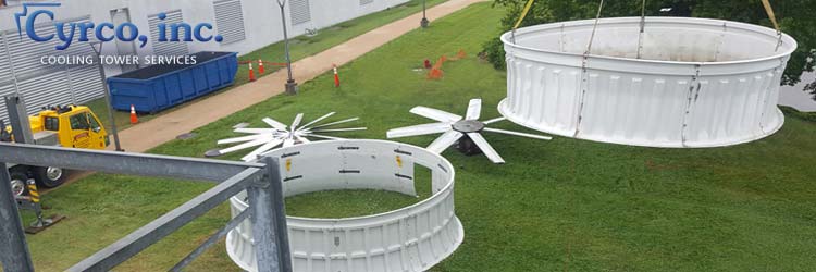 Old FRP Fan Stack Being Crane Hoisted Lowered to the Ground. New FRP Fan Stack Sits on Ground Waiting to Be Crane Hoisted to the Top of a Field Erected Cooling Tower. Old FRP Fiberglass Fan on the Ground Along with a New FRP Hudson Tuf-Lite Fan Replacement