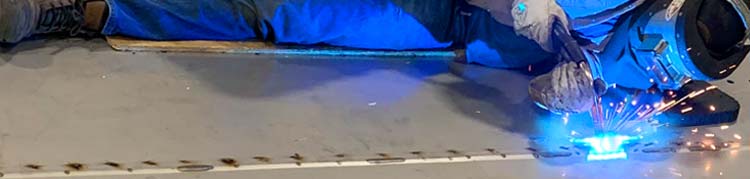 Cyrco, inc.'s Seasoned and Experienced Metal Fabrication Teams are Equipped with a Wide Range of Mig, Tig, and Stick Welders Employee welding a stainless steel sheet for a cooling tower's cold water collection basin